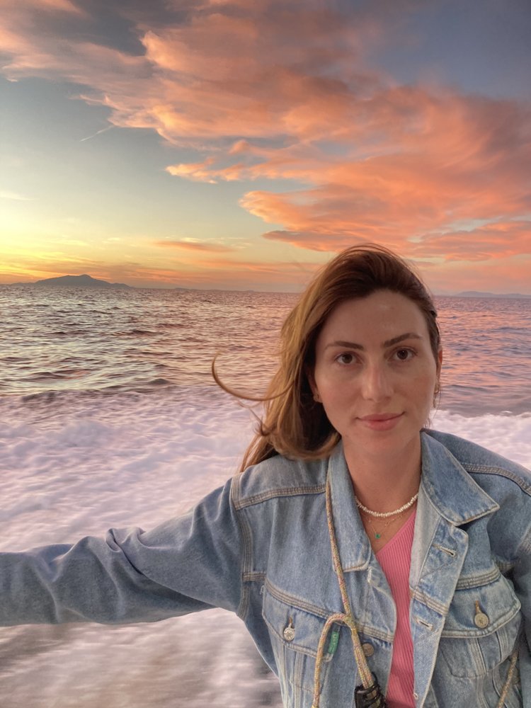 Sophia, fondatrice d'ambree Paris, au bord de la mer au coucher du soleil